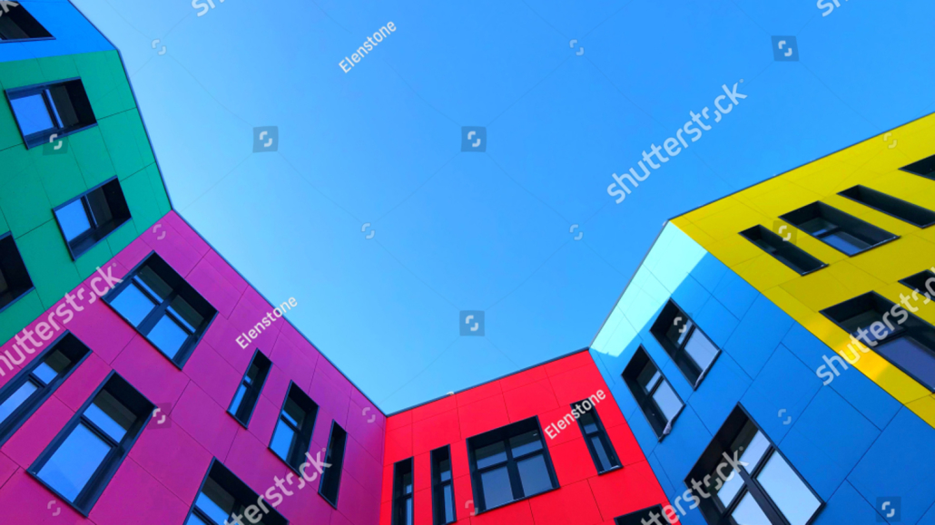 stock-photo-multi-colored-facades-of-the-school-with-black-window-frames-look-up-from-the-blue-sky-1042282198